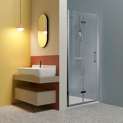 Porta doccia a libro TPS35 6mm H200cm nicchia, profili cromati, in bagno moderno con parete gialla e lavabo sospeso, anta chiusa